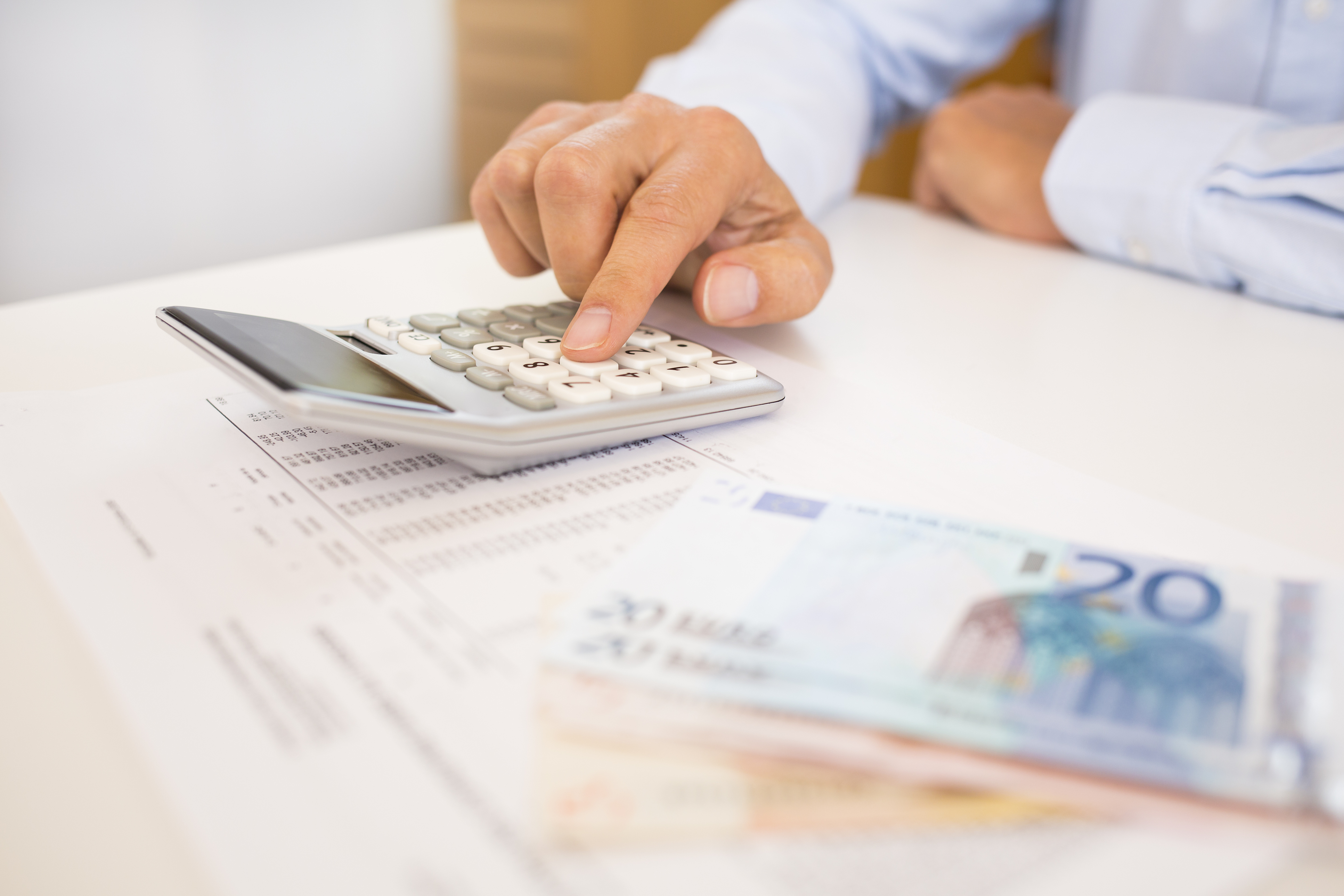 man met calculator en briefgeld